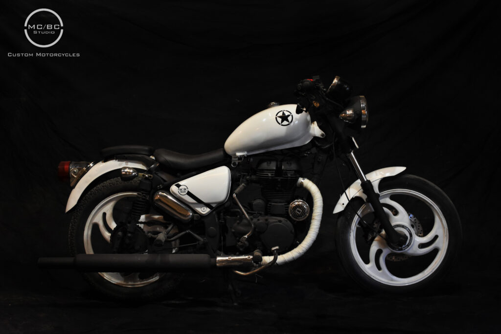 MCBC Studio custom modified motorcycle royal enfield bullet Thunderbird with an all-white paintjob with black streaks along with custom seats, custom painted mag wheels and accessories